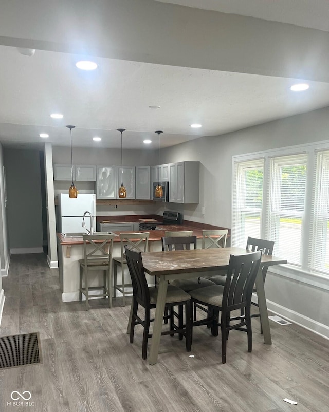 dining area with baseboards, dark wood-style flooring, and recessed lighting