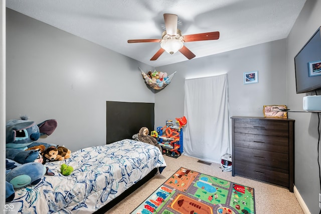 carpeted bedroom with a ceiling fan and visible vents