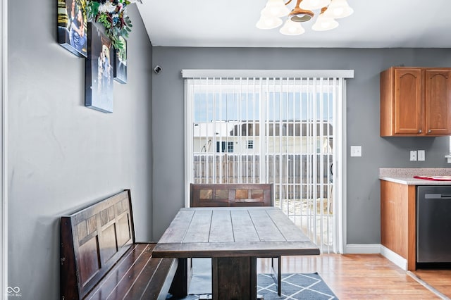 dining room with baseboards, an inviting chandelier, and light wood-style floors