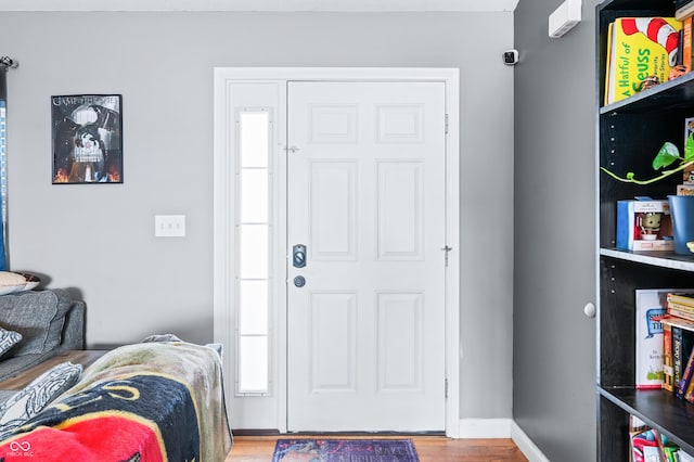 entrance foyer with baseboards and wood finished floors