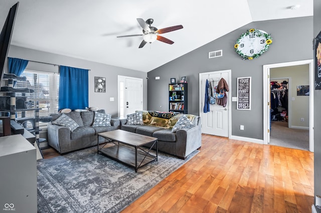 living room featuring visible vents, a ceiling fan, vaulted ceiling, wood finished floors, and baseboards