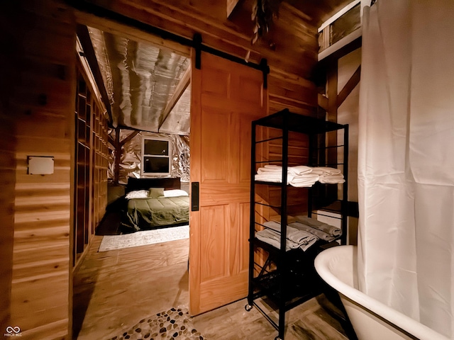 bathroom featuring a soaking tub and wooden walls