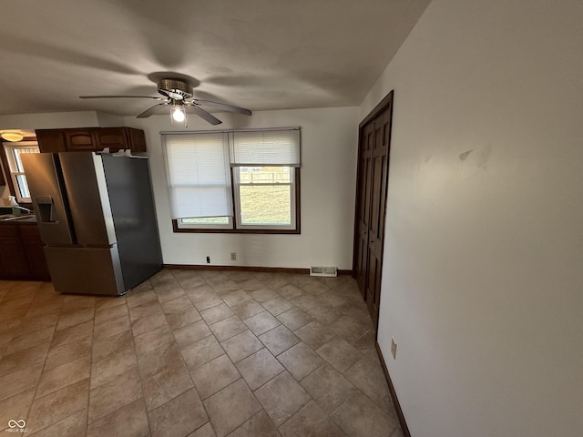 kitchen with stainless steel fridge, visible vents, baseboards, and a ceiling fan