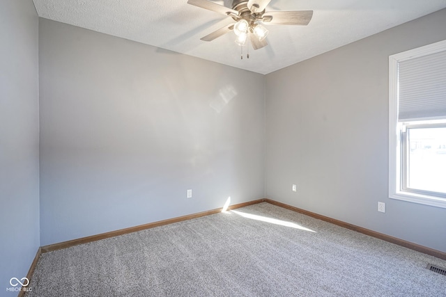 unfurnished room with a textured ceiling, ceiling fan, carpet flooring, and baseboards