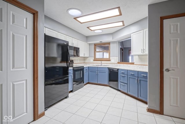 kitchen featuring white cabinets, light countertops, a sink, and black appliances