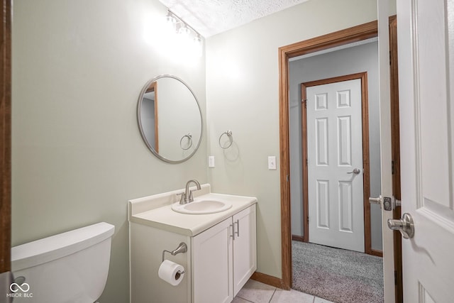 bathroom with baseboards, toilet, tile patterned floors, a textured ceiling, and vanity