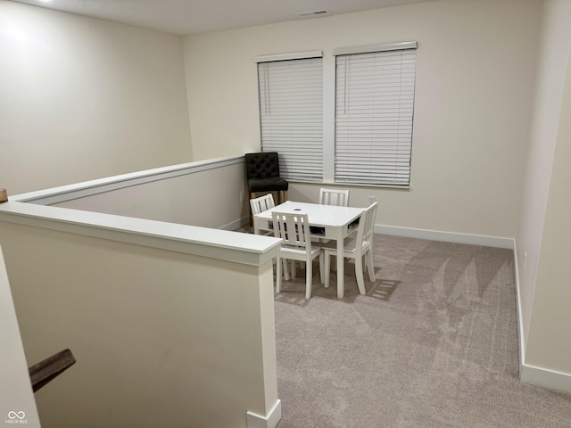 unfurnished dining area with light carpet, baseboards, and visible vents