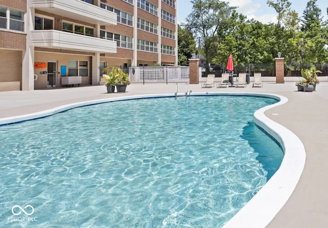 community pool featuring fence and a patio