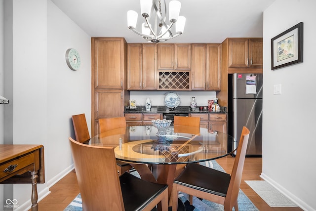 kitchen featuring dark countertops, brown cabinetry, decorative light fixtures, and freestanding refrigerator