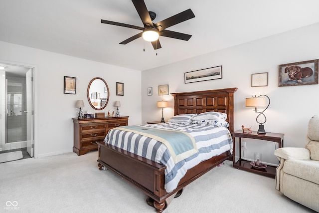 bedroom featuring ensuite bath, baseboards, a ceiling fan, and light colored carpet