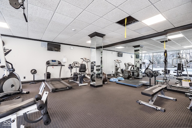 exercise room with a drop ceiling and baseboards