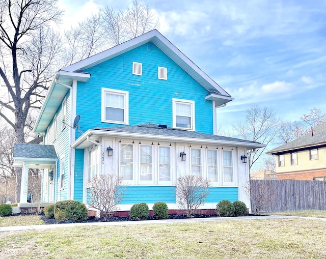 american foursquare style home with a front yard and fence