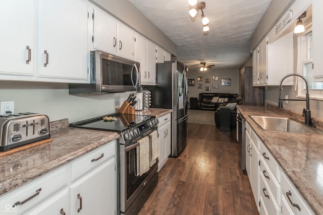 kitchen with dark wood-style floors, white cabinetry, appliances with stainless steel finishes, and a sink