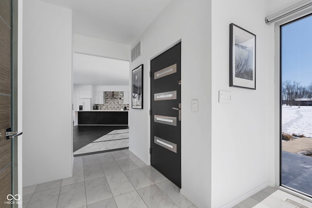 corridor with marble finish floor, baseboards, and visible vents