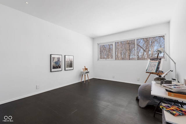 interior space with dark wood-style floors, baseboards, and a healthy amount of sunlight