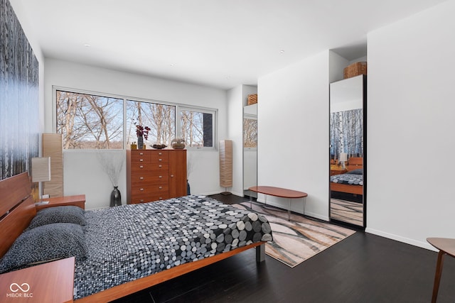 bedroom with wood finished floors and baseboards