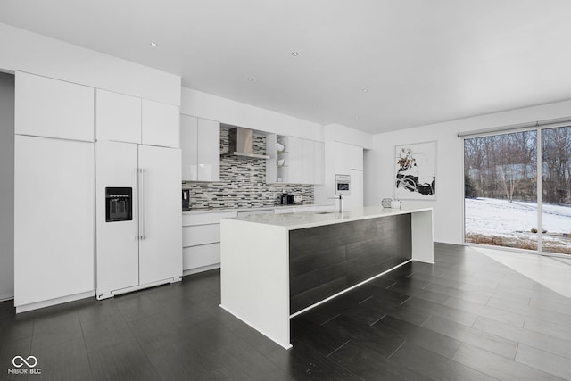 kitchen featuring light countertops, white cabinets, paneled refrigerator, and modern cabinets