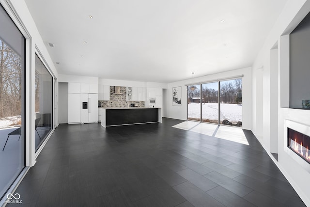 unfurnished living room with visible vents and a glass covered fireplace