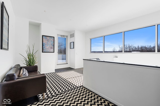 hall featuring visible vents and baseboards