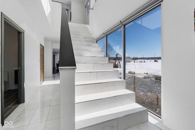 staircase featuring marble finish floor