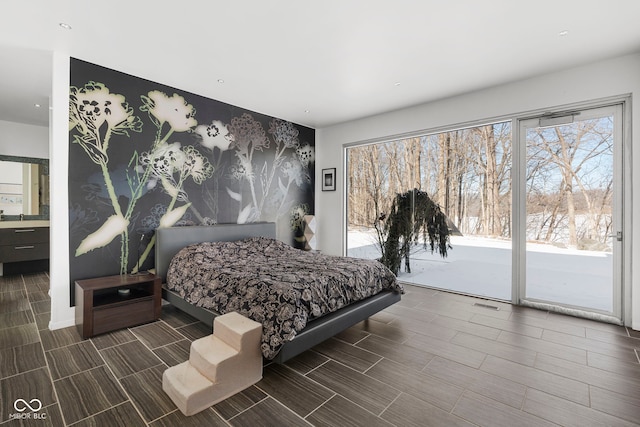 bedroom featuring access to outside, wood finish floors, and visible vents