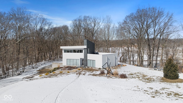 view of front of home with a chimney and stucco siding