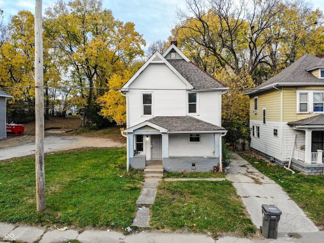 view of front of home featuring a shingled roof and a front yard