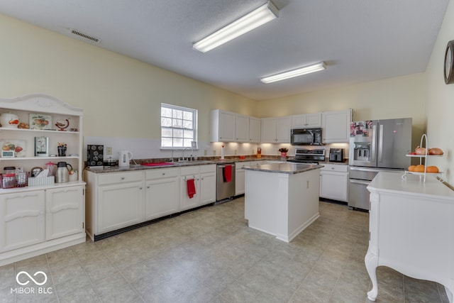 387 Legacy Blvd, Greenwood, IN 46143 - kitchen featuring appliances with stainless steel finishes, a sink, a center island, and white cabinetry