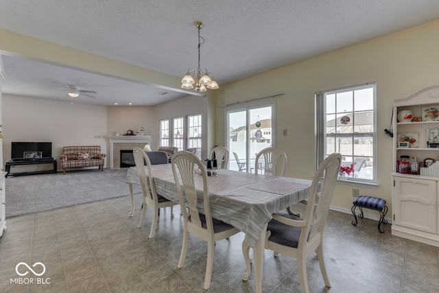 387 Legacy Blvd, Greenwood, IN 46143 - dining area featuring a chandelier, a tile fireplace, ceiling fan, light colored carpet, and baseboards