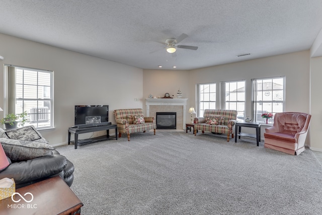 387 Legacy Blvd, Greenwood, IN 46143 - carpeted living room featuring ceiling fan, a tile fireplace, a textured ceiling, and baseboards