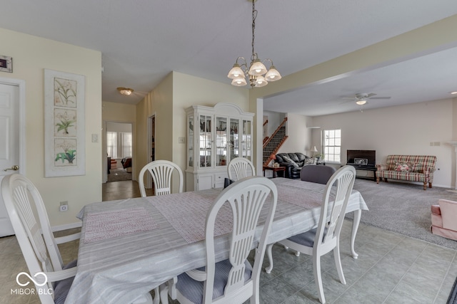 387 Legacy Blvd, Greenwood, IN 46143 - dining area featuring a chandelier, ceiling fan, baseboards, stairway, and light colored carpet