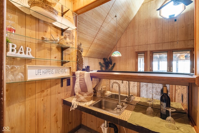 interior space featuring lofted ceiling, wooden ceiling, a sink, wood walls, and indoor wet bar