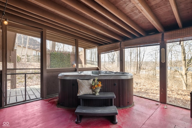 sunroom / solarium with beamed ceiling, a hot tub, and a healthy amount of sunlight