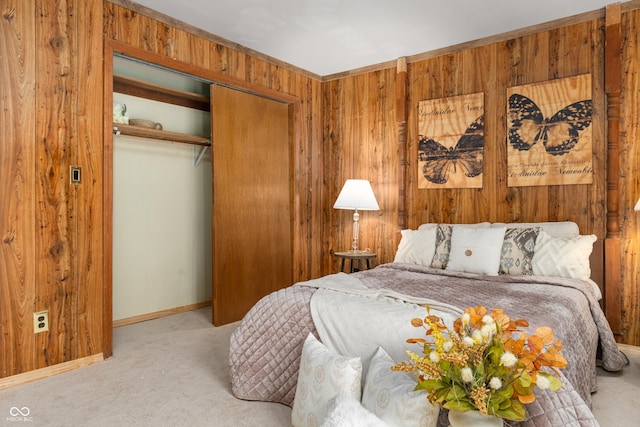 carpeted bedroom with wood walls, a closet, and baseboards