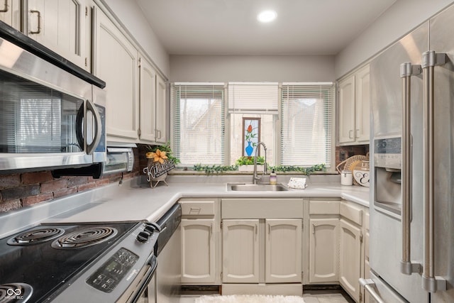 kitchen with stainless steel appliances, a sink, and light countertops