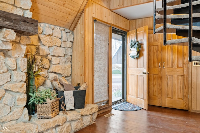 entryway featuring wood-type flooring, visible vents, vaulted ceiling, wood walls, and wooden ceiling