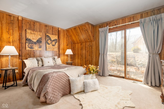 bedroom featuring wooden walls, carpet, and access to exterior