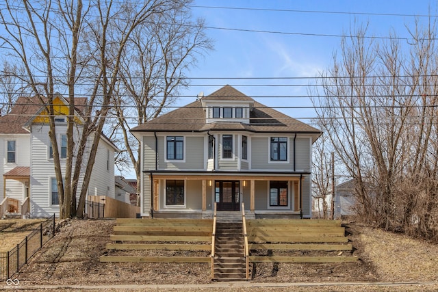 american foursquare style home with a fenced front yard, a porch, and a shingled roof