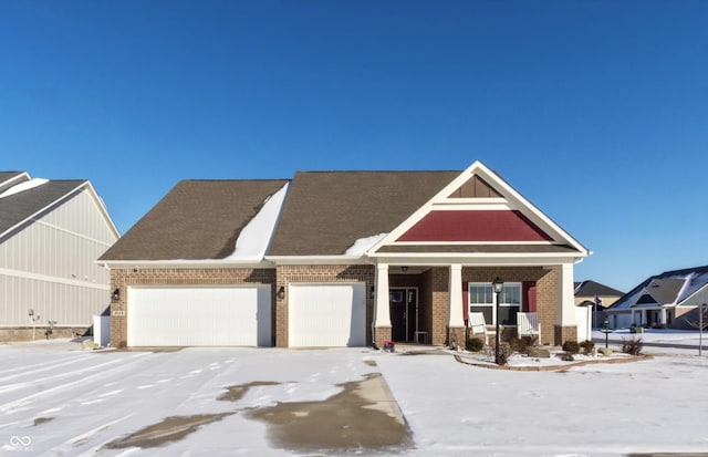 craftsman-style home featuring a garage, a porch, and brick siding