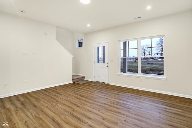 foyer with stairway, wood finished floors, visible vents, baseboards, and recessed lighting