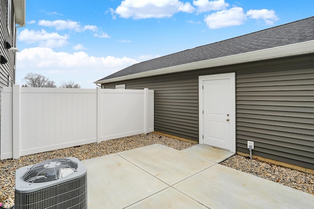 view of patio with central air condition unit and fence