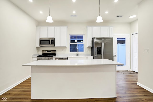 kitchen featuring white cabinetry, a center island, appliances with stainless steel finishes, and a sink