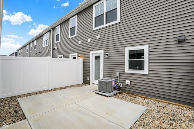 rear view of house with cooling unit, fence, and a patio area