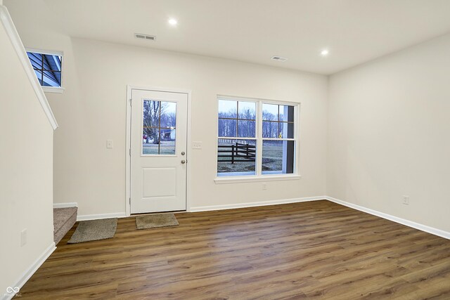 entryway with stairs, wood finished floors, and visible vents