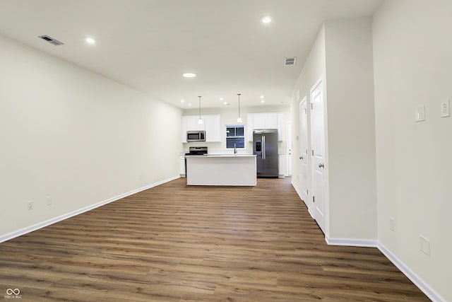 kitchen with visible vents, open floor plan, dark wood-style floors, white cabinetry, and stainless steel appliances