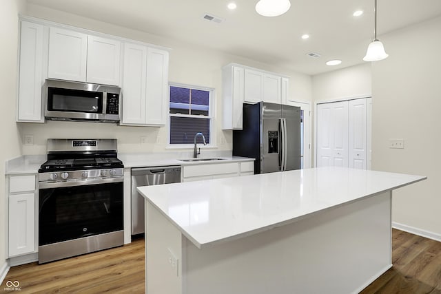 kitchen featuring visible vents, light wood-type flooring, a sink, appliances with stainless steel finishes, and white cabinets