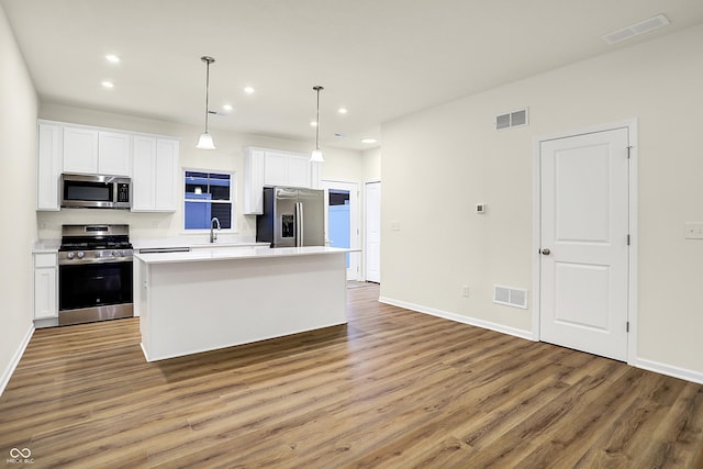 kitchen with a sink, visible vents, appliances with stainless steel finishes, and white cabinets