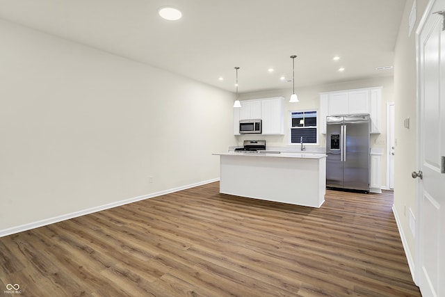 kitchen featuring a sink, recessed lighting, appliances with stainless steel finishes, white cabinets, and dark wood-style flooring