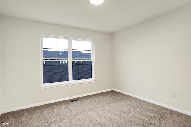 carpeted empty room with visible vents and baseboards