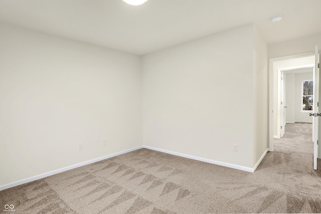 carpeted spare room with baseboards